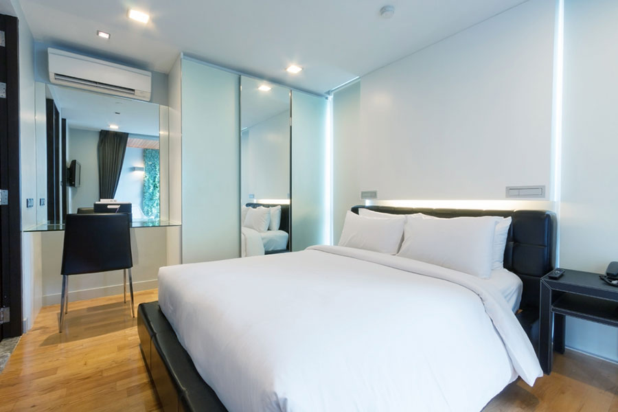 Chambre d&rsquo;h&ocirc;tel r&eacute;nov&eacute;e &agrave; Paris avec lit double, &eacute;clairage moderne, parquet et finitions soign&eacute;es